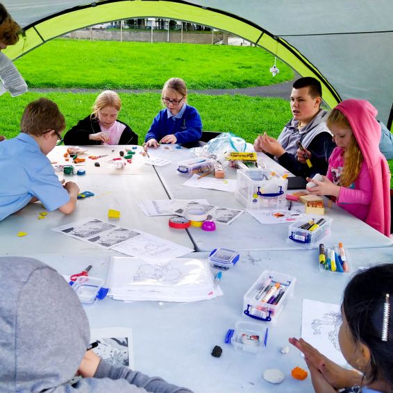 young children doing arts and crafts under a gazebo